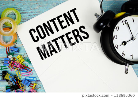Content Matters text with alarm clock and colorful office supplies on a blue wooden surface Content Matters text with alarm clock and colorful office supplies on a blue wooden surface 138693360