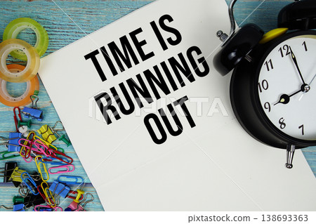 Time is Running Out text with alarm clock and colorful office supplies on a blue wooden surface 138693363