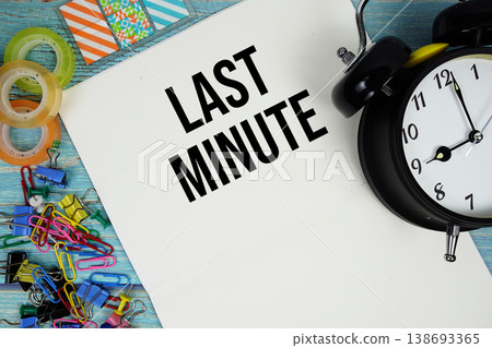 Last Minute text with alarm clock and colorful office supplies on a blue wooden surface 138693365