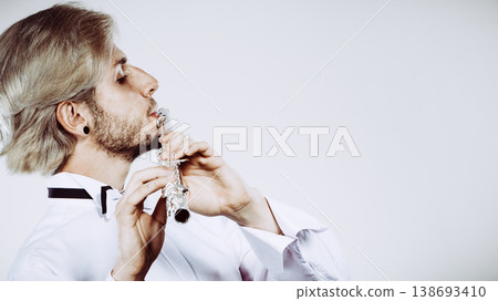 Male flutist playing his flute Male flutist playing his flute 138693410