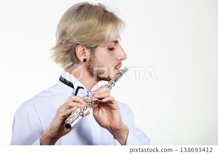Male flutist playing his flute Male flutist playing his flute 138693412