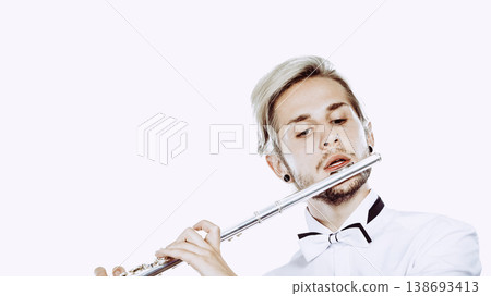 Male flutist playing his flute Male flutist playing his flute 138693413