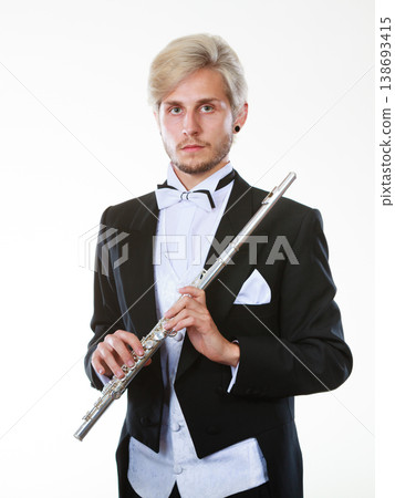 Male flutist wearing tailcoat holds flute Male flutist wearing tailcoat holds flute 138693415