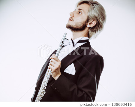 Male flutist wearing tailcoat holds flute Male flutist wearing tailcoat holds flute 138693416