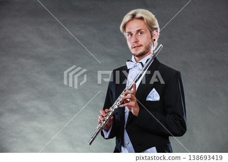 Elegantly dressed musician holding flute 138693419