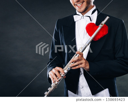 Male flutist with flute and heart. Love melody 138693423