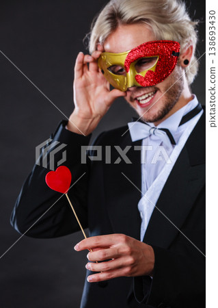 Man in carnival mask with heart stick love symbol Man in carnival mask with heart stick love symbol 138693430
