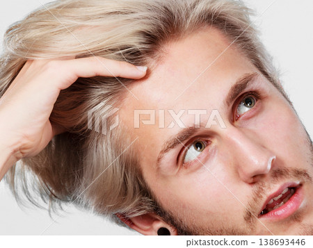 Blonde handsome guy touching his hair 138693446