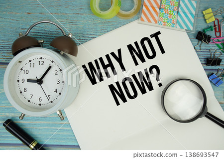 Why Not Now? text written on notepad with alarm clock and magnifying glass flat lay on wooden background 138693547