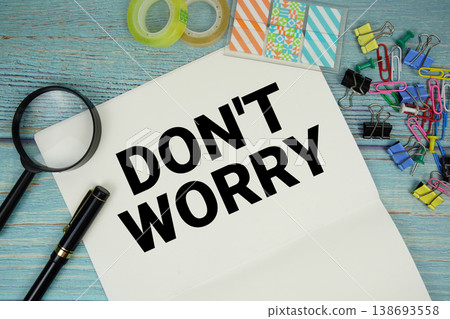 Don't Worry text written on notepad with magnifying glass flat lay on wooden background 138693558