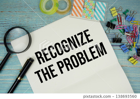 Recognize The Problem text on a paper surrounded by office supplies and magnifying glass on a blue wooden surface Recognize The Problem text on a paper surrounded by office supplies and magnifying glass on a blue wooden surface 138693560