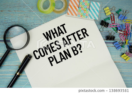 What Comes After Plan B? text on a paper surrounded by office supplies and magnifying glass on a blue wooden surface What Comes After Plan B? text on a paper surrounded by office supplies and magnifying glass on a blue wooden surface 138693581