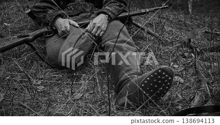 German soldier sitting in forest showcasing hobnailed jackboots and rifle German soldier sitting in forest showcasing hobnailed jackboots and rifle 138694113