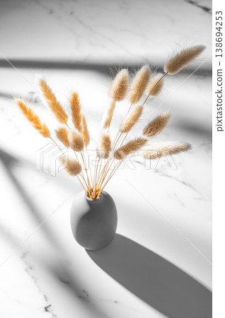 Minimalistic bouquet of dried herbs in a ceramic vase on a marble background. Minimalistic bouquet of dried herbs in a ceramic vase on a marble background. 138694253