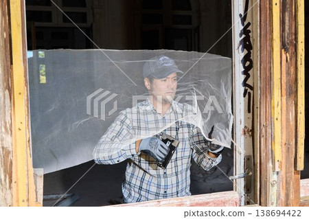 Skilled artisan installing window mesh accurately and carefully Skilled artisan installing window mesh accurately and carefully 138694422