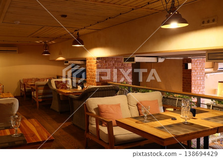 Spacious loft with communal tables and warm workspace ambiance 138694429