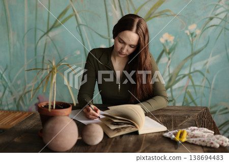 Caucasian student studying botanical references at desk Caucasian student studying botanical references at desk 138694483