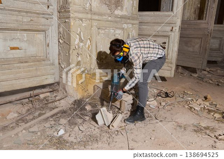 Restorers methodically clear flaky plaster from historic decorative walls 138694525