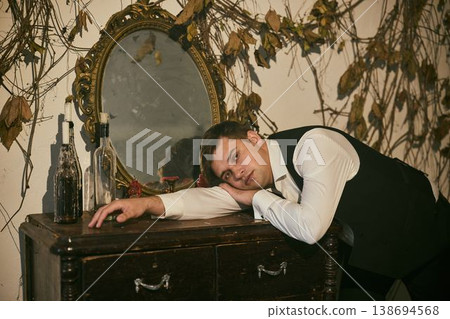 Sleepless individual leans on vintage bureau during night Sleepless individual leans on vintage bureau during night 138694568