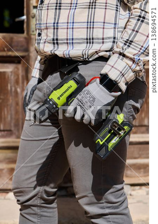 Trim specialist equipped with batterypowered tools and protective gear 138694571