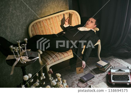 Tired playwright amidst aged scripts and theater decorations 138694575