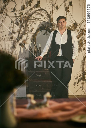 Confident individual stands with decorative mirror nearby 138694576