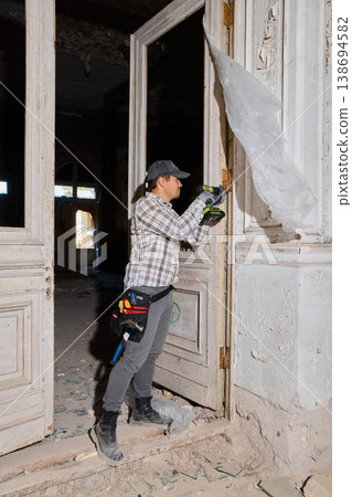 Caucasian restorer opening boarded doorway during survey Caucasian restorer opening boarded doorway during survey 138694582