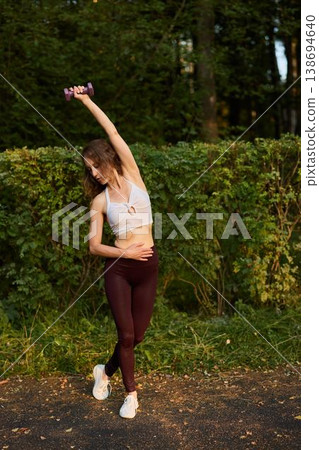 Chic lady reaching out amidst colorful natural surroundings Chic lady reaching out amidst colorful natural surroundings 138694640