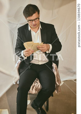 Man in formal attire analyzing legal contract pages meticulously Man in formal attire analyzing legal contract pages meticulously 138694670