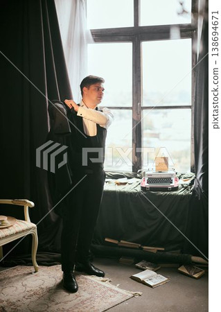 Sophisticated individual adjusts jacket in cinematic setting Sophisticated individual adjusts jacket in cinematic setting 138694671