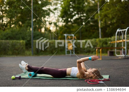 Woman performing controlled chesttoceiling press on mat 138694694