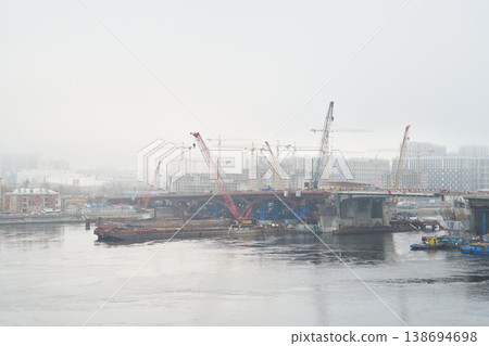 Foggy bridge construction with cranes and site engineer oversight Foggy bridge construction with cranes and site engineer oversight 138694698