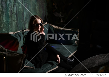 Fashionable lady appears lost in thought amid colorful surroundings Fashionable lady appears lost in thought amid colorful surroundings 138694704