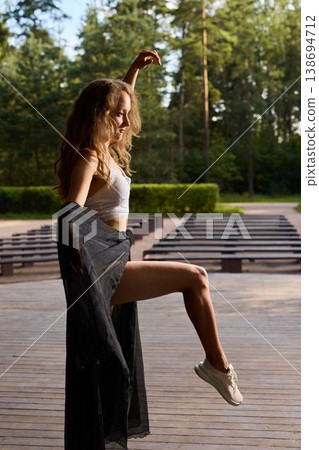 Black skirt sways as dancer performs in warm natural light Black skirt sways as dancer performs in warm natural light 138694712