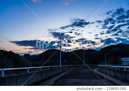夕陽西下,落日餘暉灑滿布野目水壩堤岸,對岸山脈上還殘留著淡淡的暮色和細密的烏雲① 夕陽西下,落日餘暉灑滿布野目水壩堤岸,對岸山脈上還殘留著淡淡的暮色和細密的烏雲① 138695380