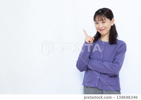 A woman pointing with a smile A woman pointing with a smile 138696346