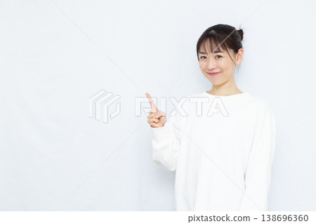 A woman pointing with a smile 138696360