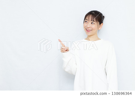 一位女士微笑著指著什麼。 138696364