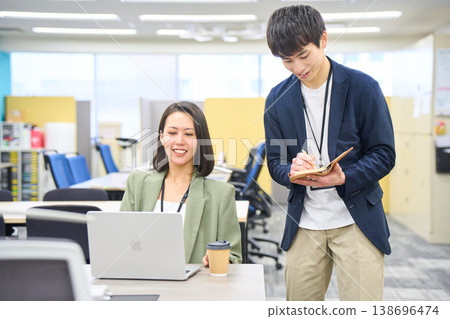 一位年輕男子正在記下女子的指示和代碼回饋。 138696474