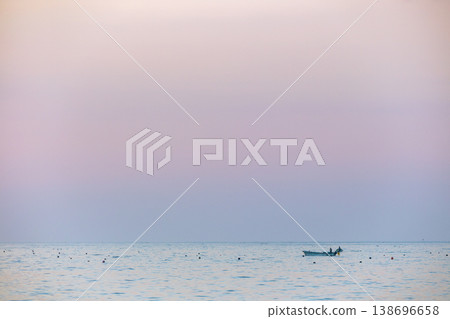 Image of a small boat floating on the sea at sunrise. Image of a small boat floating on the sea at sunrise. 138696658