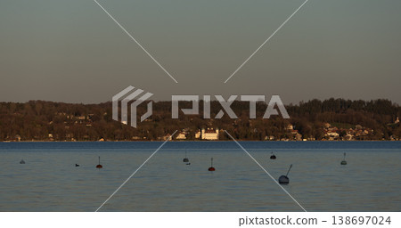 Calm lake water with mooring buoys and distant shoreline Calm lake water with mooring buoys and distant shoreline 138697024