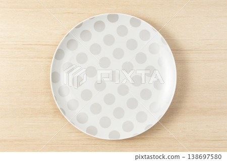 A polka-dot plate placed on the table 138697580