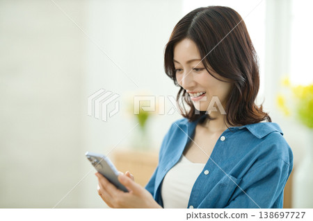 A middle-aged woman talking on her smartphone. 138697727