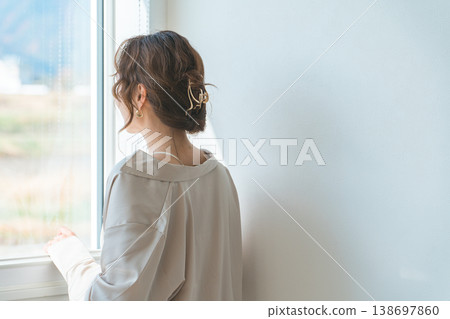 一位女子望著窗外,背影清晰可見(流露出擔憂、疲憊、焦慮、憂鬱的神情)。 一位女子望著窗外,背影清晰可見(流露出擔憂、疲憊、焦慮、憂鬱的神情)。 138697860