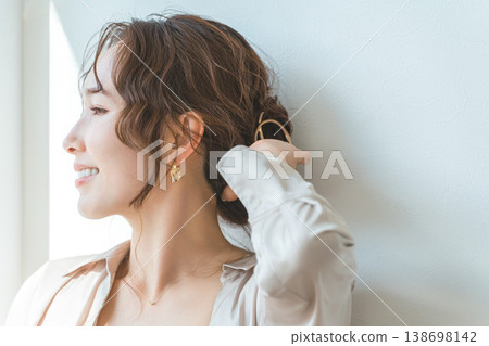 一位女士正在梳理頭髮，並戴著金色髮飾。 138698142