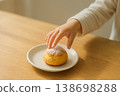 A child reaching for a cream puff 138698288