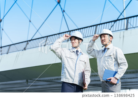 一位工程師站在公路橋前的肖像。 一位工程師站在公路橋前的肖像。 138698425
