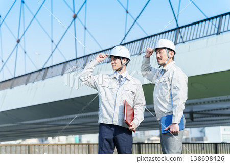 一位工程師站在公路橋前的肖像。 一位工程師站在公路橋前的肖像。 138698426