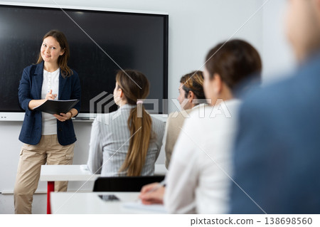 Competent female tutor teaching students in college classroom Competent female tutor teaching students in college classroom 138698560