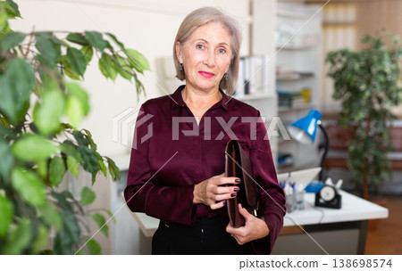 Positive mature woman working at office Positive mature woman working at office 138698574